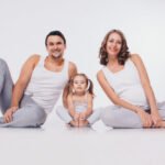 familia-feliz-envolvido-em-ginastica-recreativa-um-homem-uma-mulher-gravida-e-uma-menina-estao-sentados-no-chao-isolado_100727-115