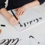 close-up-photo-of-young-woman-hands-writing-alphab-RNCVPX3.jpg