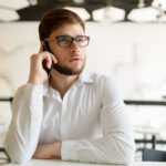 pensive-young-businessman-in-cafe-using-phone-96PXMZ8.jpg
