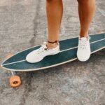 woman-in-sneakers-riding-skateboard-outdoor-on-asp-KXD8CUS.jpg